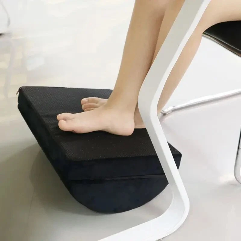El reposapiés debajo de una silla de oficina, con los pies apoyados